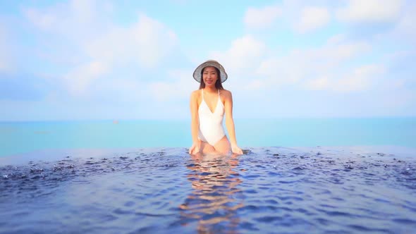 Young asian woman enjoy around outdoor swimming pool for leisure