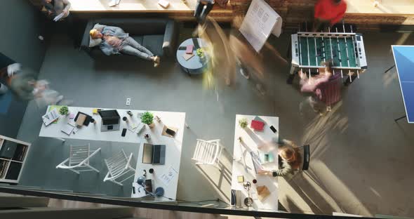 Top View Time Lapse of Group of Employees Working and Playing Table Sports in Modern Open Space