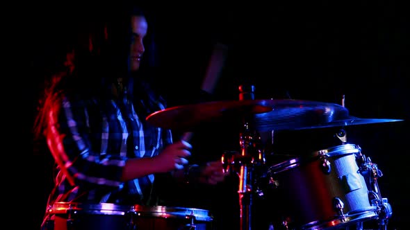 Female drummer playing on drum set
