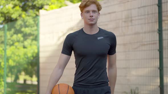 Handsome Confident Basketball Player Walking with Ball To Camera and Leaving. Portrait of Young