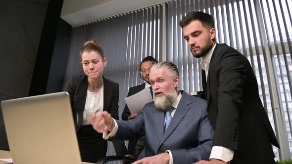 Colleagues amicably and actively discuss matters in the office of their manager