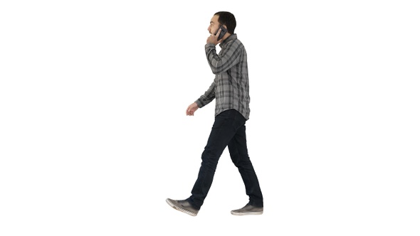 Young bearded man walking and talking on the mobile phone