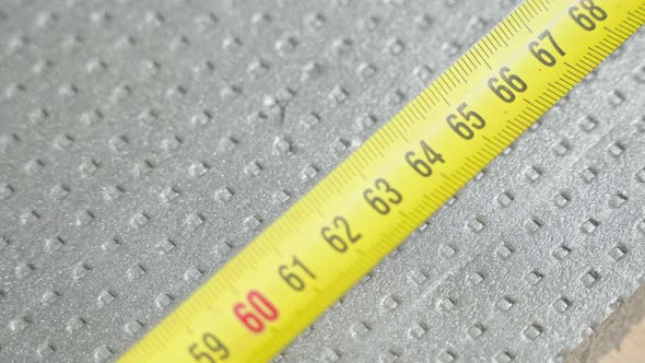 Marking the Length of Dense Foam with a Pencil with a Tape Measure Closeup