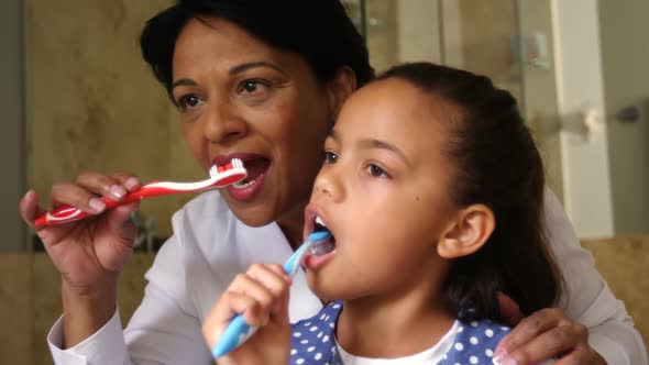 Grandmother and granddaughter brushing together in bathroom 4k