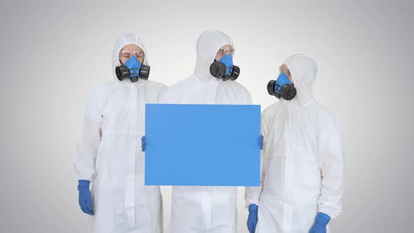 Three Doctors in Protective Suits Holding Blank Board on Gradient Background