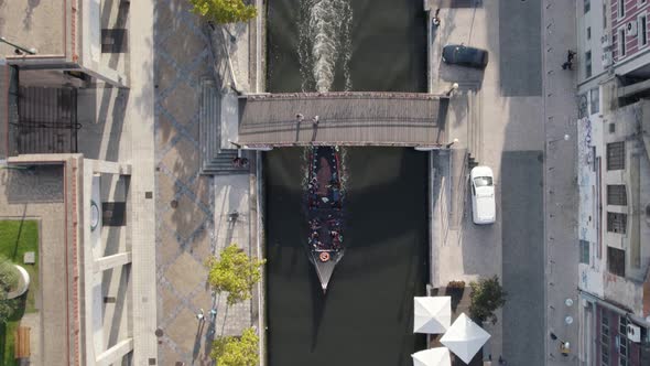 Aerial follow of Molicerio with tourists. Traditional boat on Ria de Aveiro urban canals, Portugal