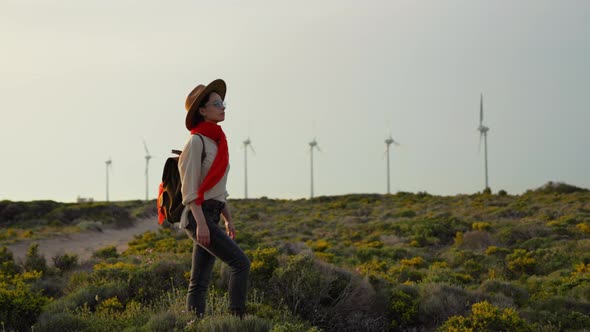 Attractive woman with red scarf on windmill farm background