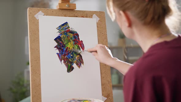 Young Woman Artist Draws a Picture with Oil Paints at Home in the Living Room