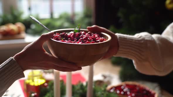 Closeup Hands of Unrecognizable Young Woman and Man Passing Delicious Food Sitting at Festive