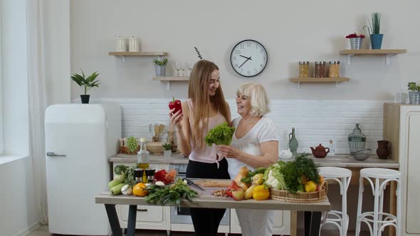 Mature Woman with Grandchild Girl Recommending Eating Raw Vegetable Food. World Vegan Day Concept