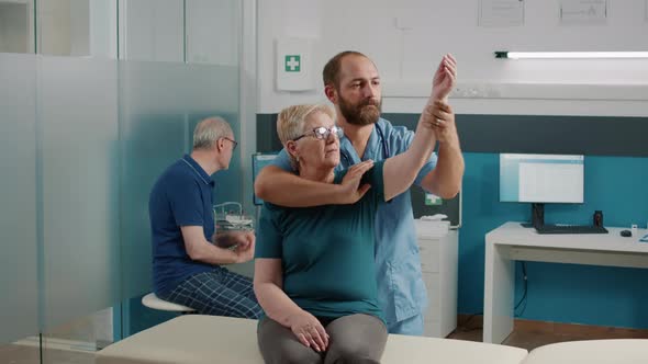 Orhopedic Specialist Doing Arms Stretch Exercise with Elder Patient