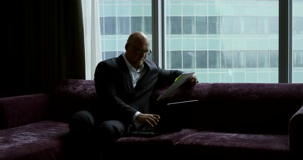 Lawyer Is Filling Up Paper and Reading Information on Display of Notebook in Office