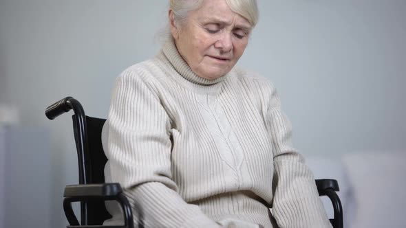 Elderly Woman in Wheelchair Massaging Painful Knee Joints, Health Problems