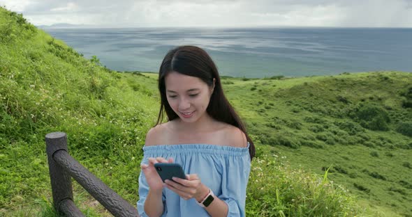 Woman take selfie on mobile phone in ishigaki island landmark