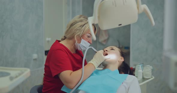 Dentist Works in a Bright Room with Modern Equipment