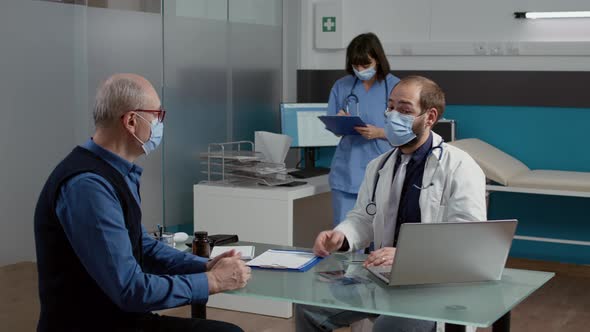 Male Doctor Doing Medical Consultation with Old Patient