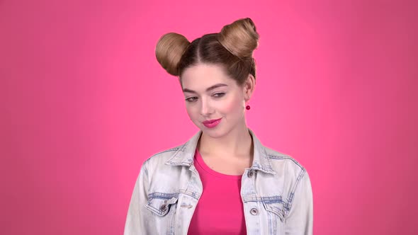 Girl Shows the Heart Shape with Her Hands. Pink Background. Slow Motion