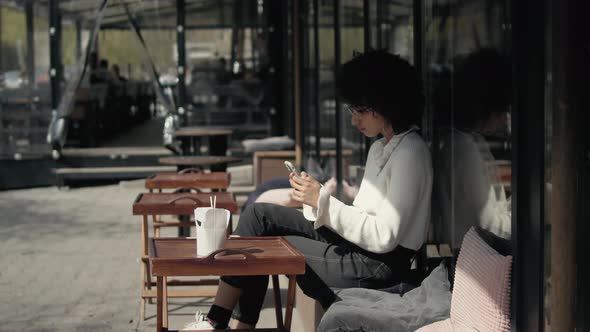 Woman With Afro Hairstyle Using Smartphone