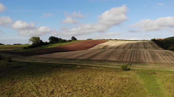 Aerial view of golden fields with brown mold close to Sejerøbugten in Odsherred.