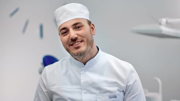 Close Up Face of Handsome Dental Surgeon Laughing at Workplace