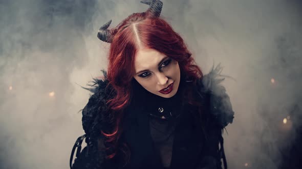 Ritual of Occultism or Esoterics Concept. Red-haired Girl Witch with Black Horns Sitting on Floor in