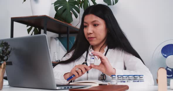 Professional Beautiful Mixed Race Doctor Woman Shows Vaccine Treatment Medication to Remote Client
