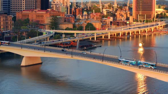 Aerial View Of City Bus and Vehicles Driving On Victoria Bridge Over Brisbane River At Sunset In QLD