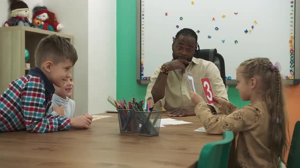 African American Teacher and Students Play a Game While Studying Numbers in the Classroom