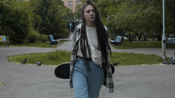 Girl skateboarder walking outdoors