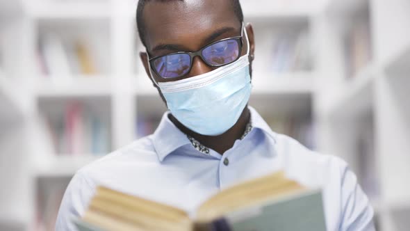 University Library: African American Man in a Mask During Quarantine Covid-19 Prepares for the Exam