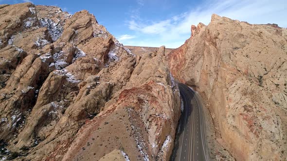 Panning aerial view of road cutting through canyon gorge