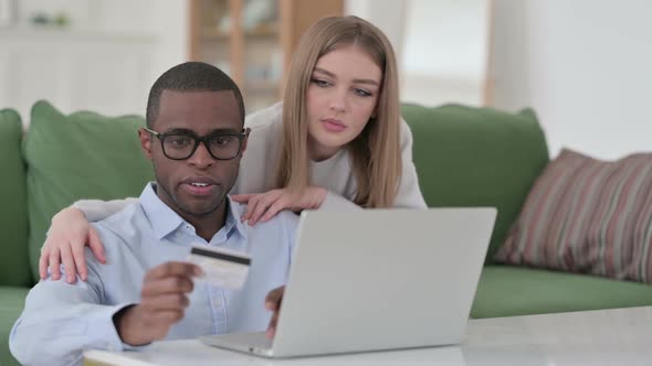 Mixed Race Couple Doing Successful Online Shopping on Laptop