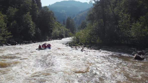 People Rafting on Mountain River Back View