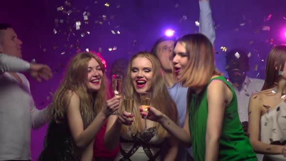 Close-up of Girls Clinking Glasses and Drinking Champagne. Slow Motion