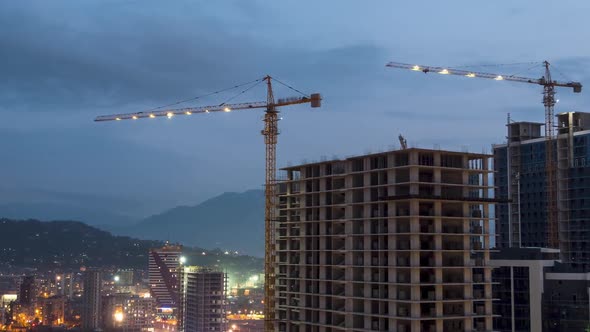 Building Construction From Day To Night. Timelapse. Tower Crane with Lighting on a Construction Site