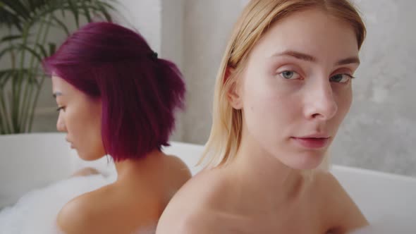 Portrait of Pretty Blonde Woman Sitting in Bath with Female Friend