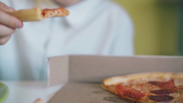 Schoolboy Takes Pizza From Box at Dinner in Room Closeup