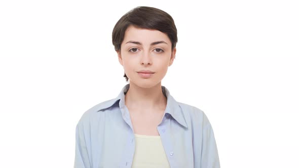 Young Brunette Caucasian Girl with Short Hairstyle Looking Calmly at Camera and Smiling