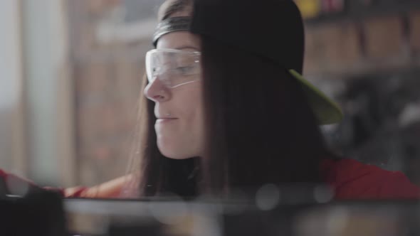 Portrait Skill Woman in a Cap and Protective Glasses with Pierced Lip and Ring in Nose Measuring