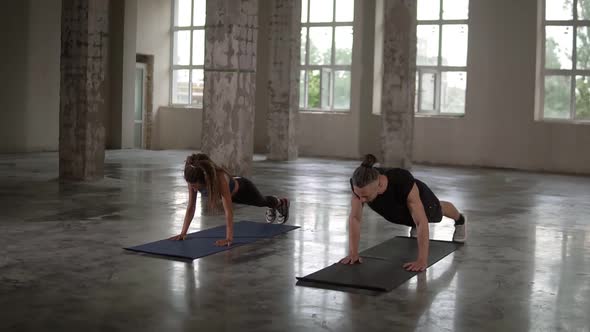 Man and Woman Pushups at Empty Loft Studio with Columns