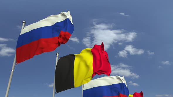 Flags of Belgium and Russia Against Blue Sky