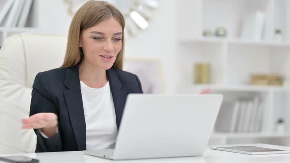 Professional Businesswoman Doing Video Call on Laptop in Office