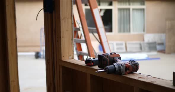 Power tools and drill on the lumber framing of a home construction site.