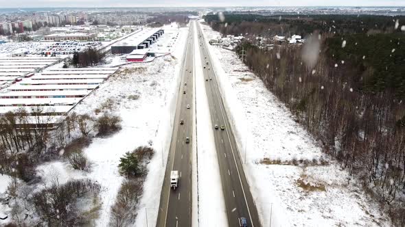 Vehicles driving through A1 highway in winter season during heavy snowfall, aerial view