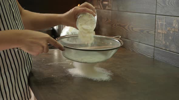 Sieving flour on the kitchen countertop