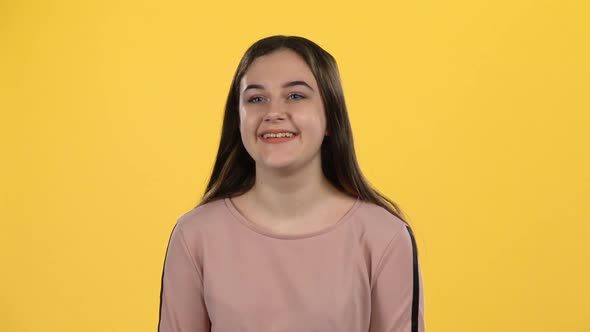 Portrait Teenager Posing Playfully on Yellow Background. Slow Motion