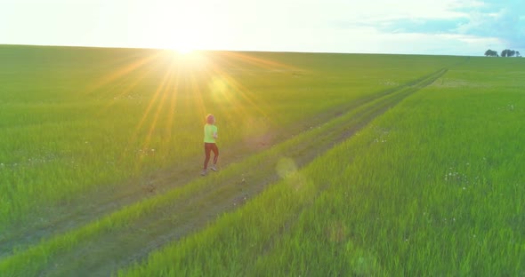 Sporty Child Runs Through a Green Wheat Field