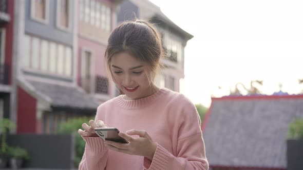 Asian backpacker blogger woman using smartphone taking selfie while traveling at Chinatown.