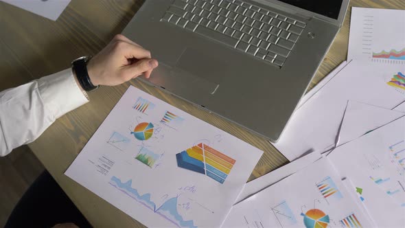 businessman hands make notes on paper with graphs