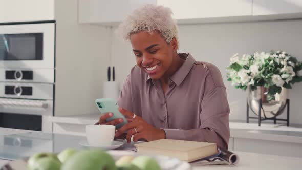 African American Woman Rejoices After Reading SMS on Phone Celebrates Victory